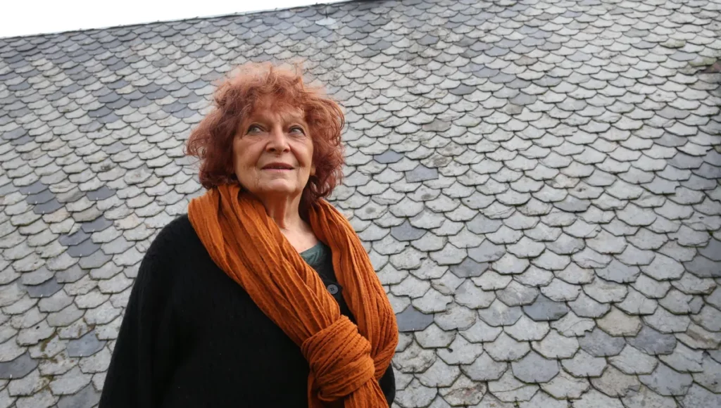 portrait de la romancière Claudie Hunzinger. Elle porte une grande écharpe couleur fauve assortie à sa chevelure rousse