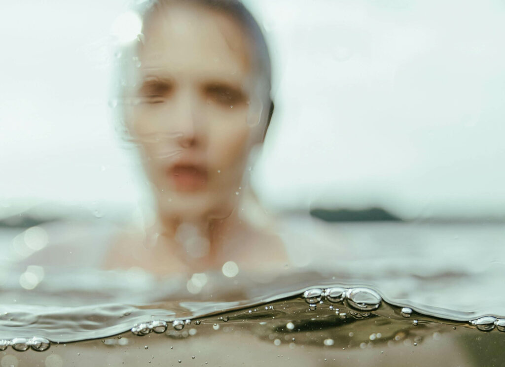une femme invisibilisée par le flou de l'eau, comme un féminin sacré sous un plafond de verre